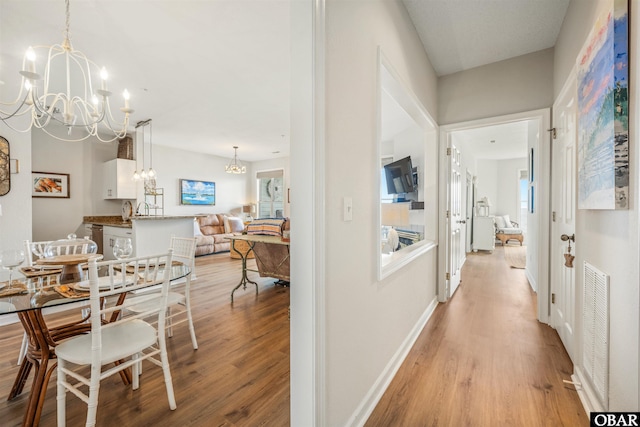 1113 Pirates Way Unit 1113, Manteo, NC 27954 - hall with a chandelier, light wood-type flooring, and baseboards