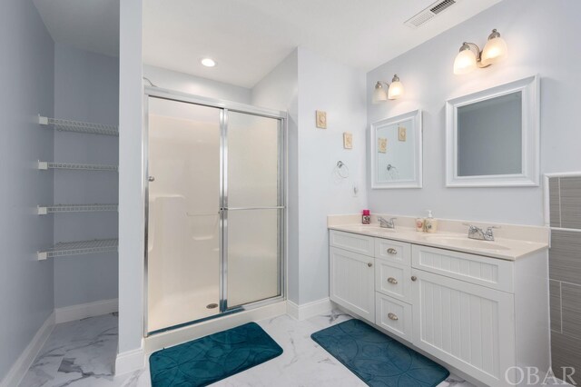 full bath with marble finish floor, visible vents, a sink, and a stall shower