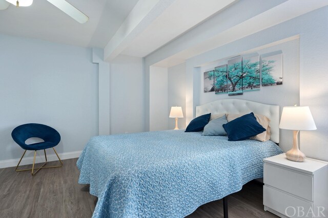 bedroom with ceiling fan, beamed ceiling, wood finished floors, and baseboards