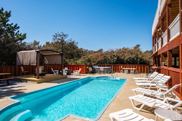 view of swimming pool featuring a pergola, fence, a deck, and a fenced in pool