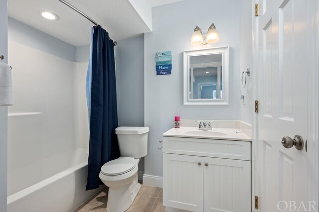 bathroom with toilet, shower / bath combo with shower curtain, vanity, baseboards, and tile patterned floors