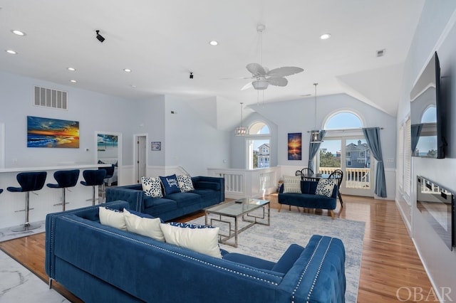 living area with recessed lighting, visible vents, vaulted ceiling, and light wood finished floors