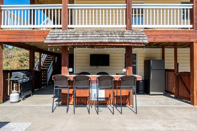 view of patio / terrace featuring stairs, exterior bar, and grilling area