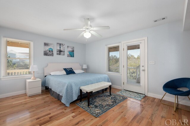 bedroom featuring access to outside, visible vents, light wood-style flooring, and baseboards