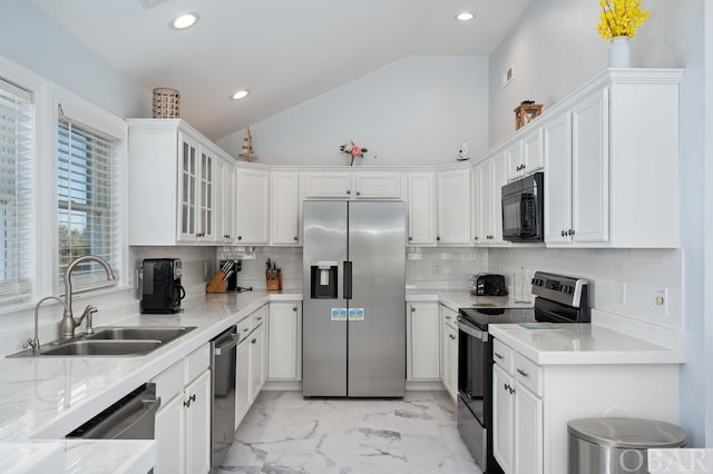 kitchen featuring marble finish floor, appliances with stainless steel finishes, glass insert cabinets, white cabinetry, and a sink