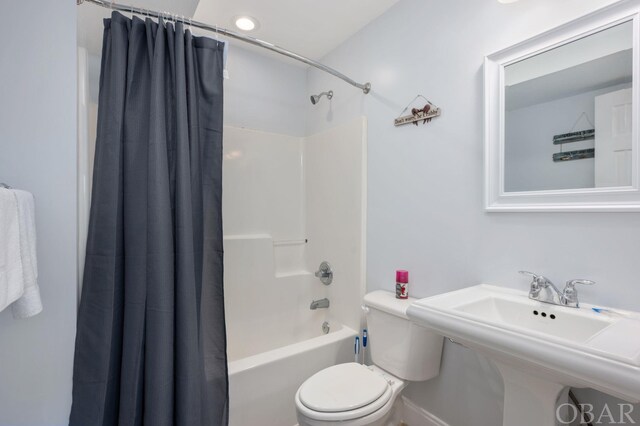 full bathroom featuring toilet, a sink, and shower / tub combo with curtain