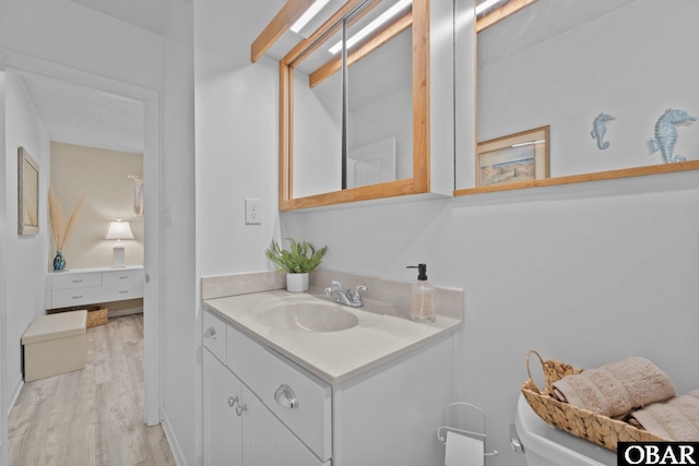 bathroom featuring vanity, wood finished floors, and toilet