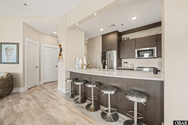 202 Dartmoor Ave Unit 202-C, Manteo, NC 27954 - kitchen featuring appliances with stainless steel finishes, a breakfast bar area, a sink, a peninsula, and recessed lighting