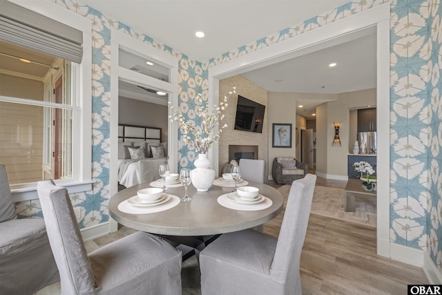 202 Dartmoor Ave Unit 202-C, Manteo, NC 27954 - dining area featuring wallpapered walls, baseboards, a large fireplace, and wood finished floors