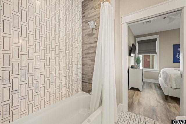 202 Dartmoor Ave Unit 202-C, Manteo, NC 27954 - ensuite bathroom with shower / bathtub combination with curtain, baseboards, and wood finished floors