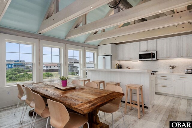 5118 N Virginia Dare Trl Lot 7, Kitty Hawk, NC 27949 - dining space featuring light wood-style floors, plenty of natural light, beam ceiling, and high vaulted ceiling
