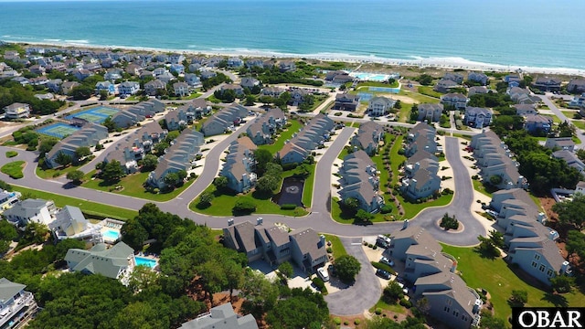 drone / aerial view featuring a view of the beach, a residential view, and a water view