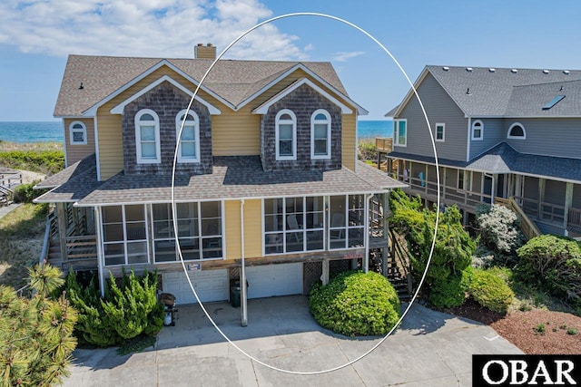 5307 S Virginia Dare Trl Unit B, Nags Head, NC 27959 - view of front facade featuring a chimney, a shingled roof, an attached garage, and a sunroom