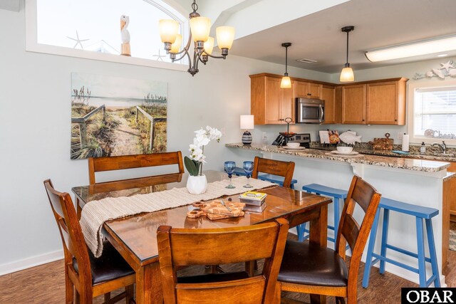 dining space featuring a chandelier, dark wood-style flooring, visible vents, and baseboards