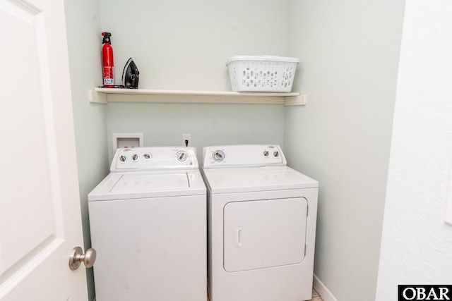 clothes washing area featuring laundry area, baseboards, and separate washer and dryer