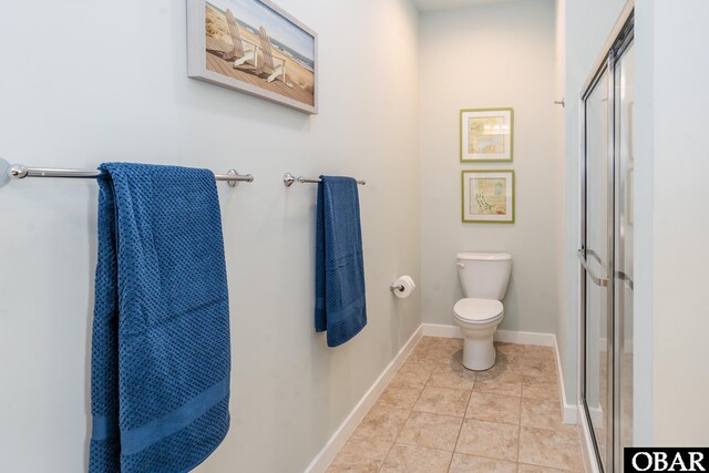 bathroom with toilet, tile patterned flooring, baseboards, and a shower with shower door