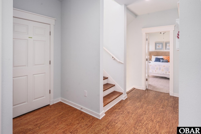 staircase featuring baseboards and wood finished floors