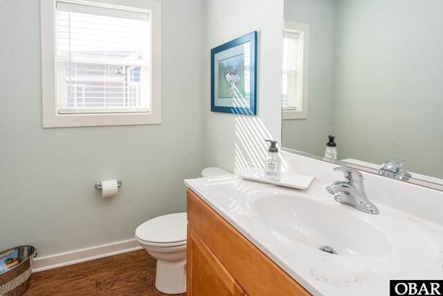 bathroom featuring baseboards, vanity, toilet, and wood finished floors