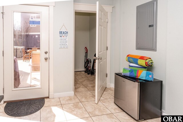 interior space with light tile patterned floors, electric panel, and baseboards