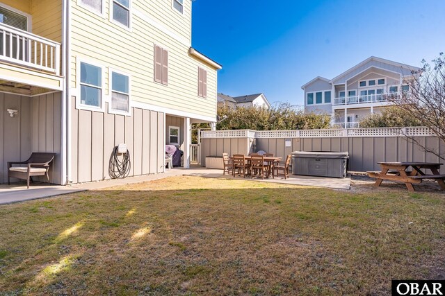 view of yard featuring a balcony, a hot tub, fence, and a patio