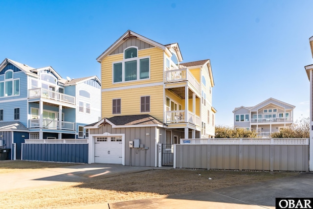 view of front of home featuring an attached garage, driveway, fence, and board and batten siding