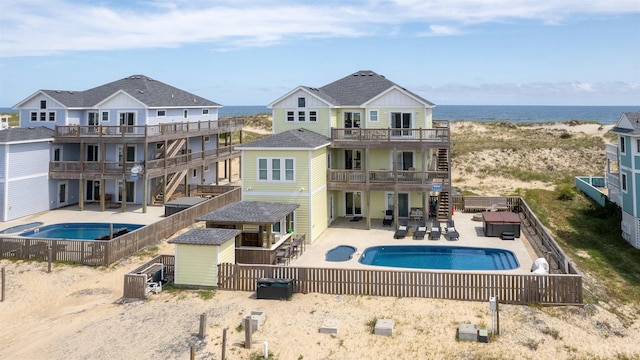 view of swimming pool with an outbuilding, a patio, a fenced backyard, an in ground hot tub, and a storage unit