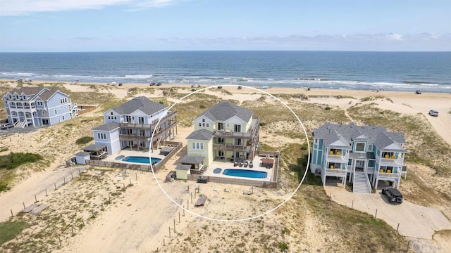 birds eye view of property featuring a water view and a beach view