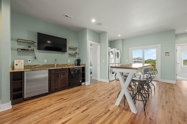 2103 Sandfiddler Rd Lot # 25, Corolla, NC 27927 - indoor wet bar with stacked washing machine and dryer, stainless steel refrigerator, light wood-style floors, baseboards, and recessed lighting