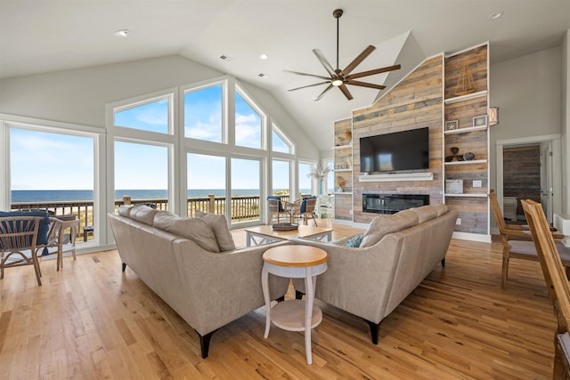 2103 Sandfiddler Rd Lot # 25, Corolla, NC 27927 - living area with a fireplace, ceiling fan, a water view, light wood-type flooring, and high vaulted ceiling