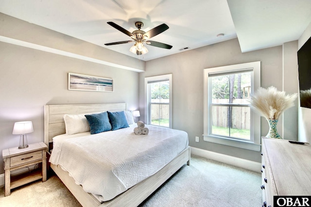 bedroom with baseboards, light carpet, visible vents, and ceiling fan