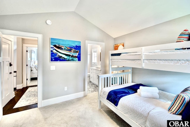 bedroom with baseboards, carpet, ensuite bath, and vaulted ceiling