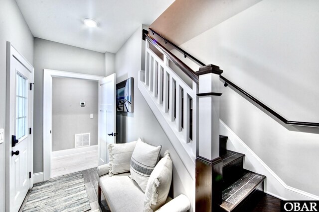 stairway featuring visible vents, baseboards, and wood finished floors