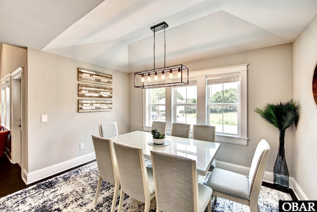 dining area featuring baseboards, wood finished floors, and vaulted ceiling