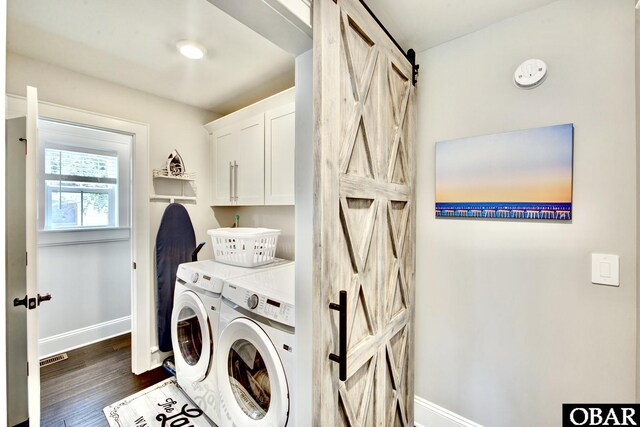 clothes washing area with baseboards, cabinet space, dark wood-style flooring, a barn door, and independent washer and dryer