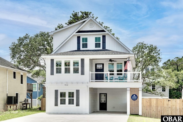 view of front facade featuring board and batten siding, fence, central AC unit, a carport, and driveway