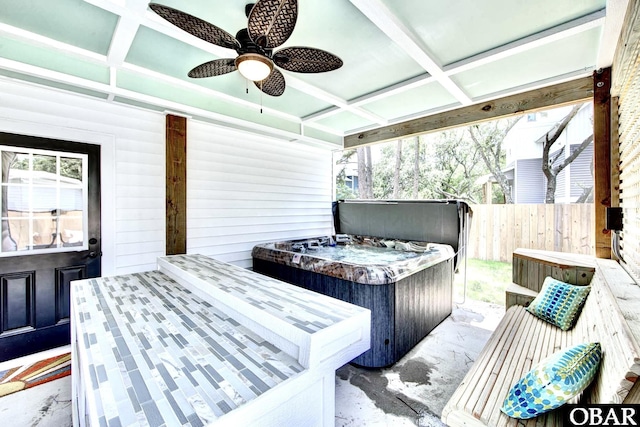 deck with ceiling fan, fence, and a hot tub