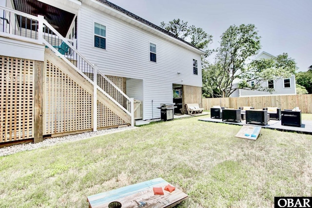 back of house featuring fence, a yard, outdoor lounge area, stairs, and a patio area