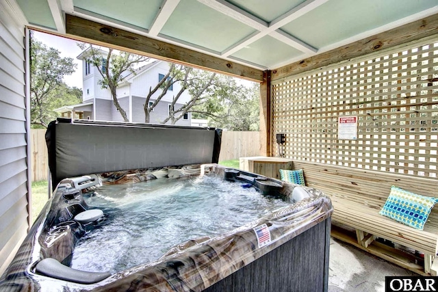 wooden deck with a hot tub and fence