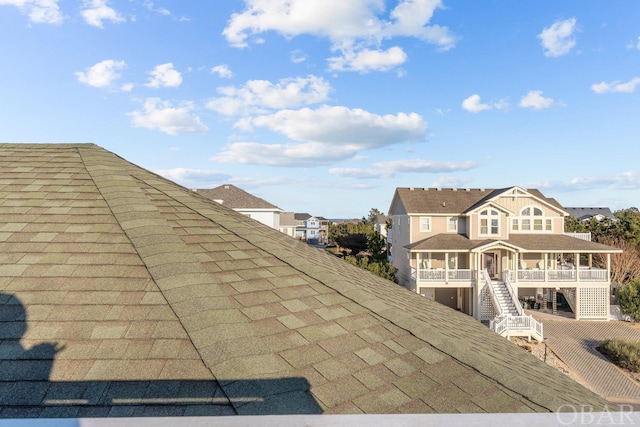 details featuring a residential view, stairway, and roof with shingles