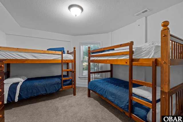 carpeted bedroom featuring visible vents and a textured ceiling