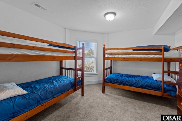 carpeted bedroom featuring visible vents and a textured ceiling