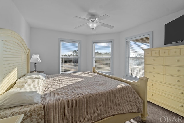 carpeted bedroom featuring multiple windows and a ceiling fan