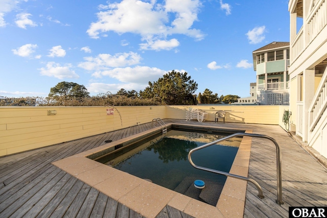 view of swimming pool with a wooden deck, fence private yard, and a fenced in pool