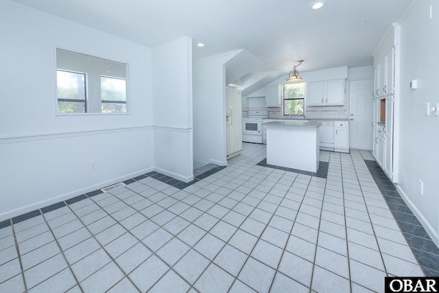 5707 Caratoke Hwy, Poplar Branch, NC 27965 - kitchen with a kitchen island, baseboards, light countertops, white cabinets, and electric stove
