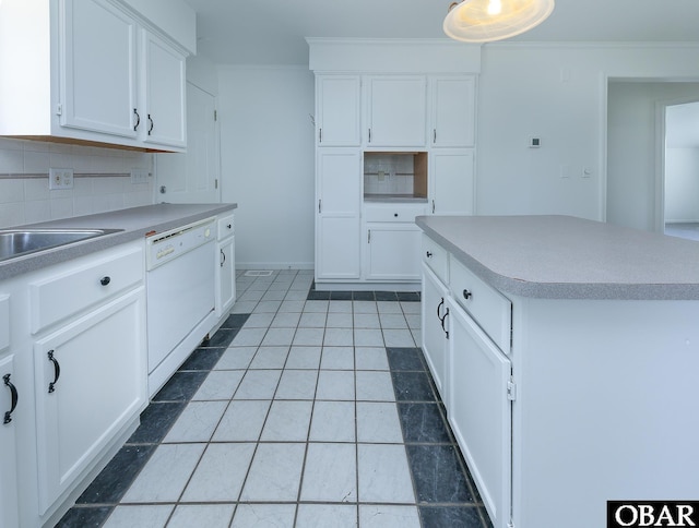 5707 Caratoke Hwy, Poplar Branch, NC 27965 - kitchen with decorative backsplash, crown molding, dishwasher, light countertops, and white cabinets