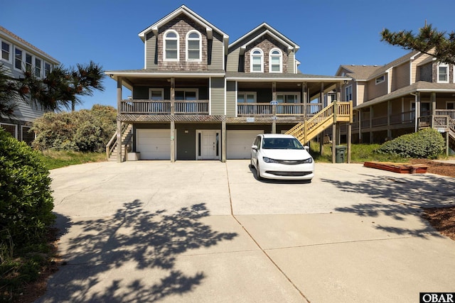 view of front of property with driveway, a garage, stairs, and a porch