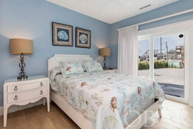 bedroom featuring access to exterior, ceiling fan, visible vents, and wood finished floors