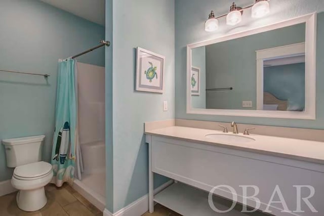 full bath featuring a stall shower, vanity, toilet, and baseboards