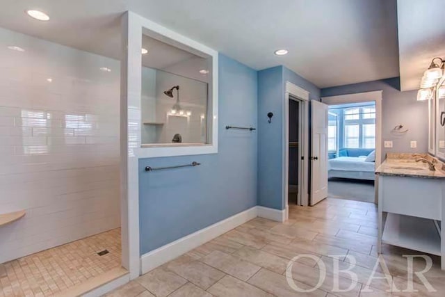 ensuite bathroom featuring a walk in shower, connected bathroom, recessed lighting, vanity, and baseboards