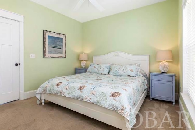 bedroom with baseboards, ceiling fan, and light colored carpet